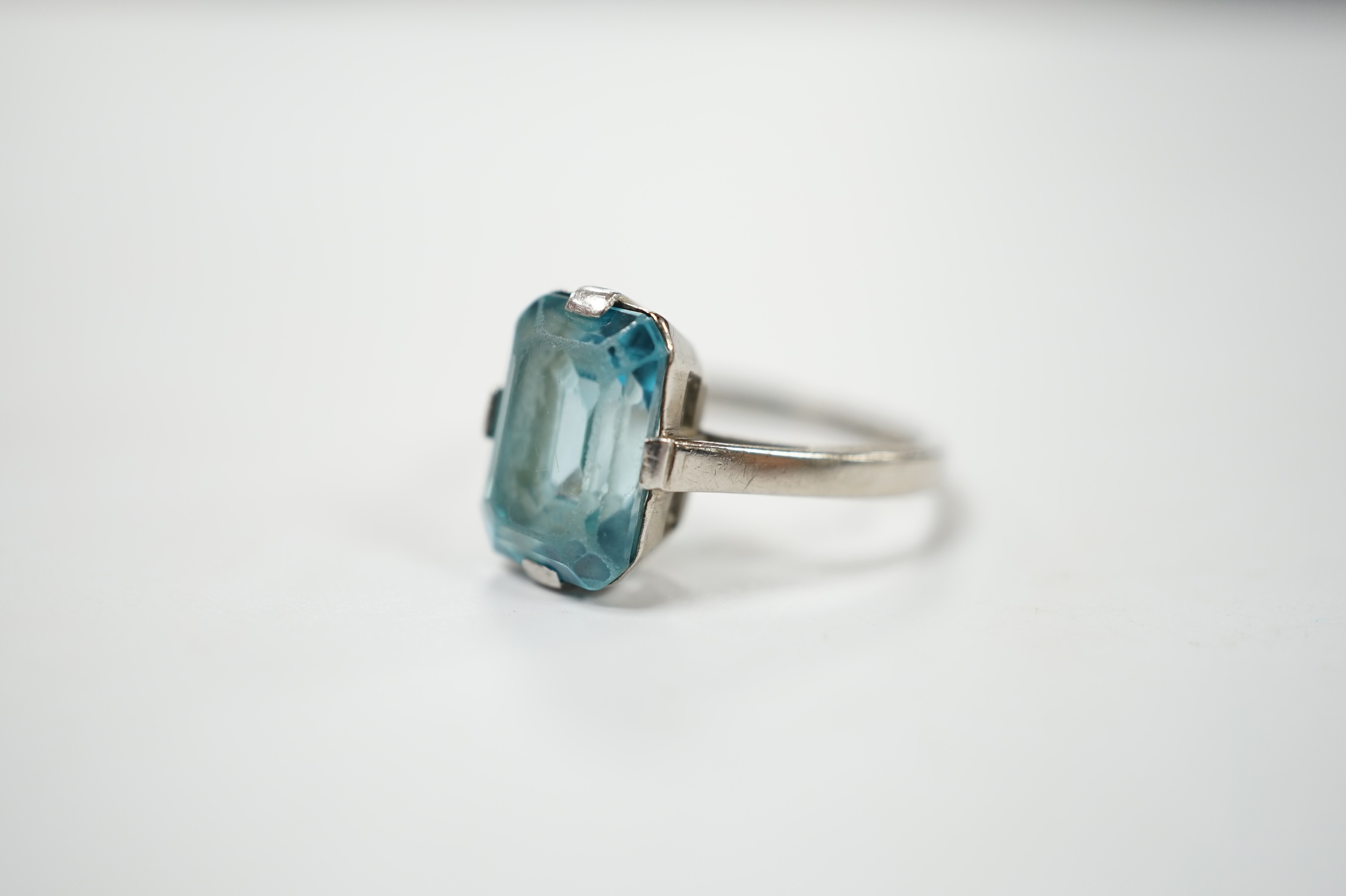 A mid 20th century white metal (stamped platinum) and single stone emerald cut blue zircon set ring, size K, gross weight 3.9 grams. Condition - poor to fair